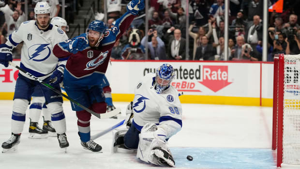 Colorado Avalanche left wing J.T. Compher, left, celebrates next to Tampa Bay Lightning goaltender Andrei Vasilevskiy, right, after an overtime goal by Andre Burakovsky in Game 1 of the NHL hockey Stanley Cup Final on Wednesday, June 15, 2022, in Denver.
